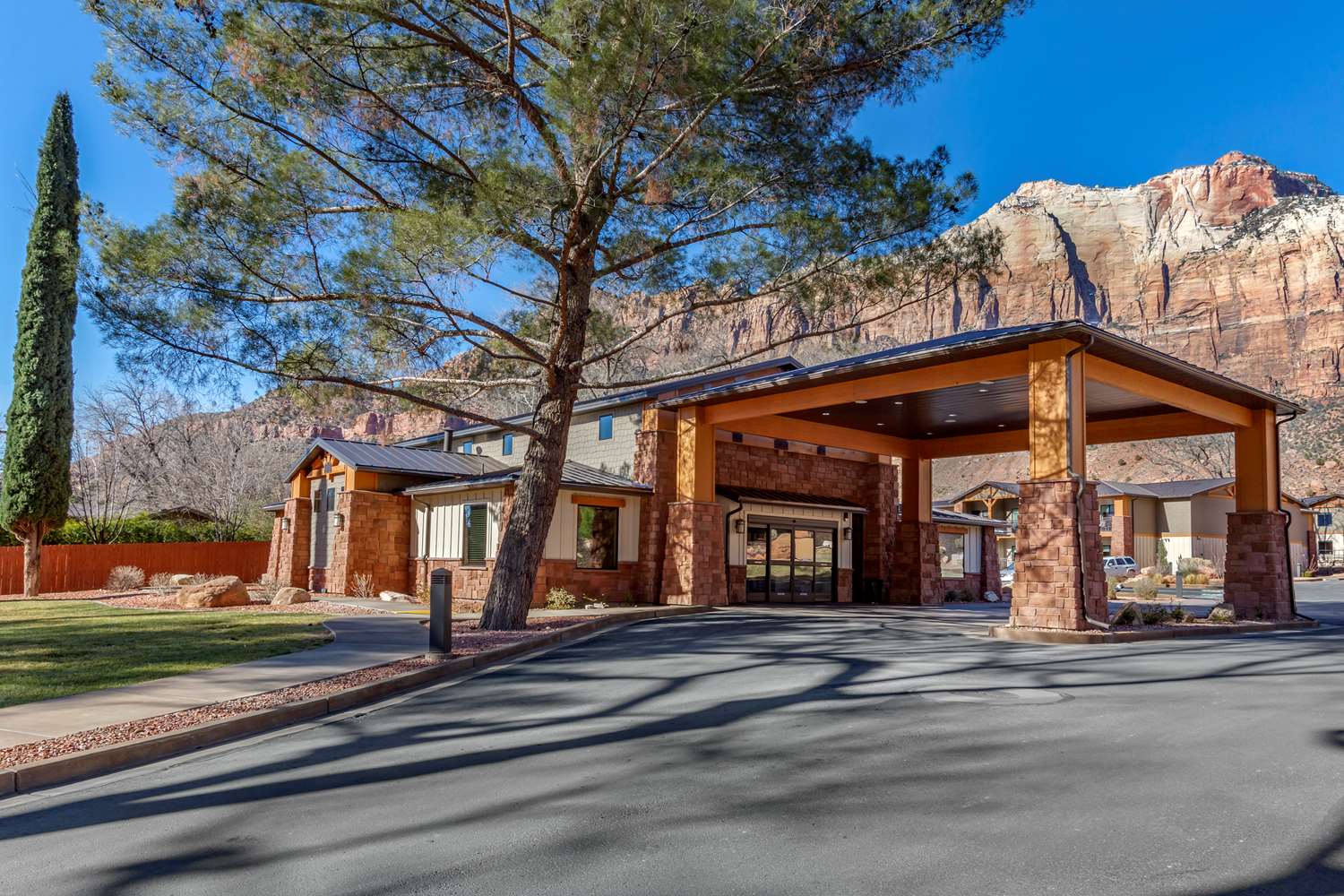 Nestled amidst the breathtaking mountain landscape and just steps from Zion National Park, the Best Western Plus Zion Canyon Inn & Suites offers the perfect blend of comfort and convenience for your Zion National Park lodging experience. Located within walking distance of the park entrance, local dining, and shopping, this hotel is ideal for travelers looking to immerse themselves in the beauty of Zion National Park without the hassle of long commutes. Enjoy easy access to the free Zion shuttle service, available from March through November, right at the hotel’s entrance. This Zion hotel boasts serene views from private balconies, allowing guests to unwind and take in the awe-inspiring surroundings. Set back from the main road, it offers a peaceful escape perfect for those seeking a tranquil yet centrally located retreat. Whether you’re planning a day of adventure or a leisurely visit, the Best Western Plus Zion Canyon Inn & Suites provides an unmatched blend of convenience, comfort, and stunning scenery that will enhance your Zion National Park experience.